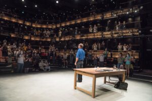 Photo of Ralph Fiennes facing the audience at the Bridge Theatre at the end of a peformance of David Hare's Beat The Devil