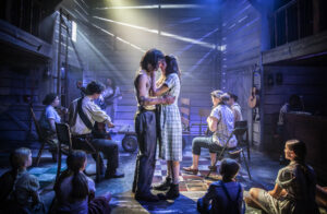 Production photo from Whistle Down The Wind at The Watermill Theatre Newbury 2022 showing Robert Tripolino and Lydia White