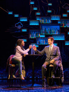 Two actors Tanisha Spring and AndyKarl raises glasses in a bar in a scene from the stage musical Groundhog Day at The Old Vic in London June 2023