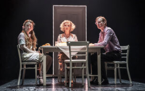 Three actors, namely Laurie Ogden, Charlie Brooks and Trevor Fox, sit round a kitchen table in the stage play The Ocean at the End of the Lane