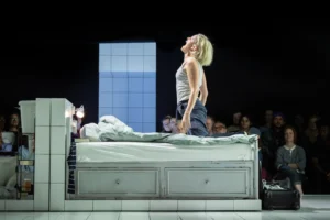 A woman screaming on a bed in a scene from People, Places and Things at Trafalgar Theatre