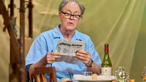 Actor John Lithgow sits reading the Literary Review 